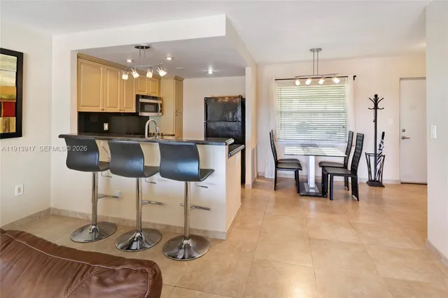 a kitchen with stainless steel appliances granite countertop a table and chairs in it