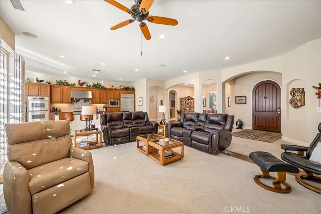 a dining room with furniture a chandelier and wooden floor