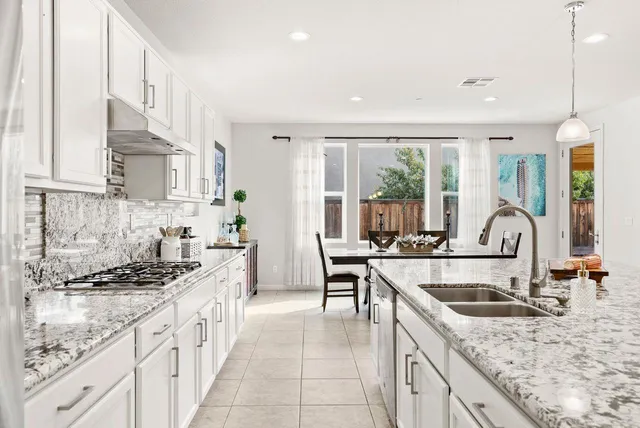 a kitchen with stainless steel appliances granite countertop a sink stove and cabinets