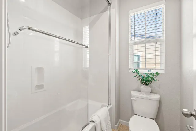 a white toilet sitting next to a bath tub