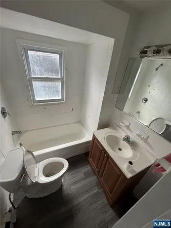 a bathroom with a tub sink and mirror