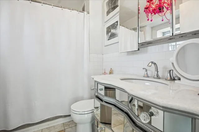 a bathroom with a granite countertop toilet sink and mirror