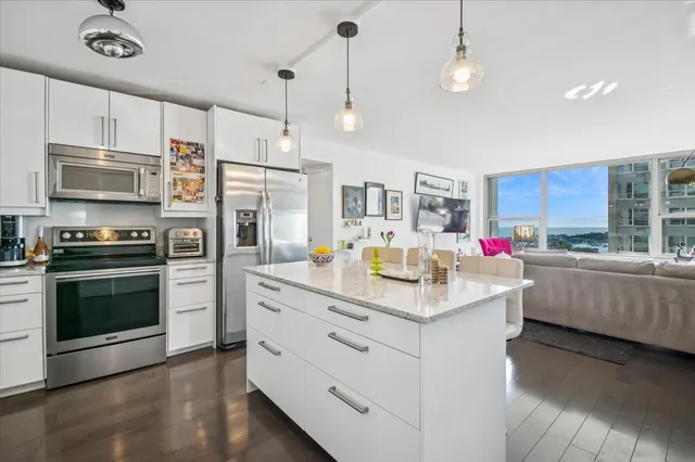 a kitchen with stainless steel appliances kitchen island granite countertop a stove and a sink