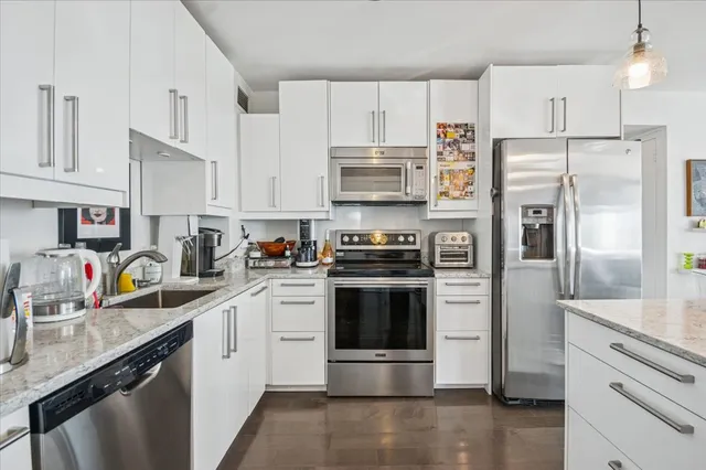 a kitchen with stainless steel appliances a refrigerator sink and microwave