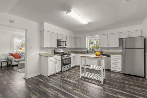 a kitchen with white cabinets and stainless steel appliances