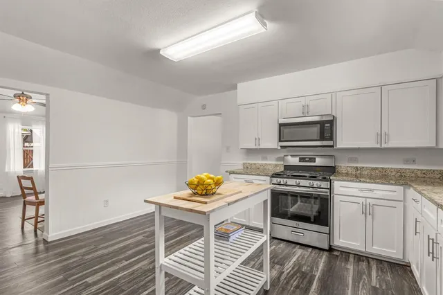 a kitchen with stainless steel appliances a stove a sink and cabinets