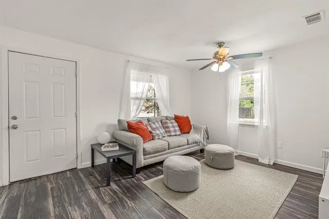 a living room with furniture a window and a potted plant