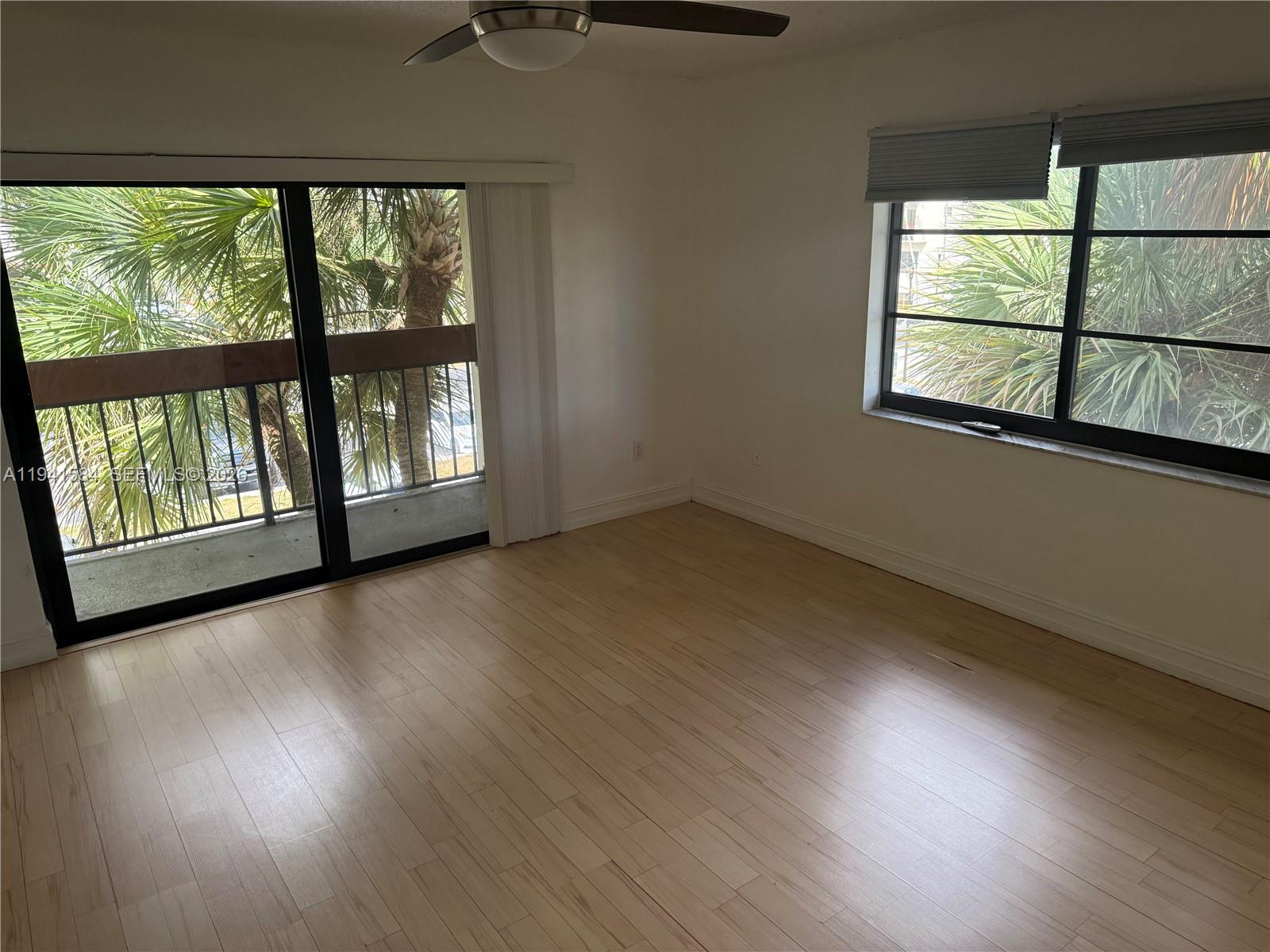 8620 Southwest 149th Avenue, Unit 416 Miami, FL 33193 - Photo 20 of 21 an empty room with wooden floor and windows