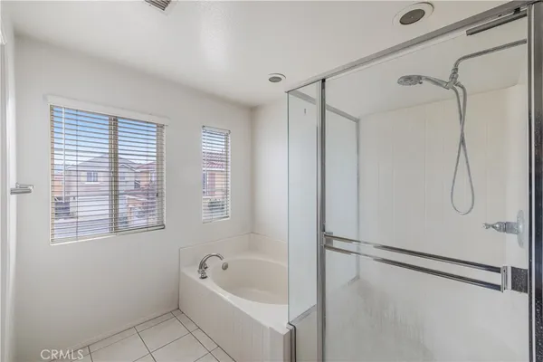 a bathroom with a tub a shower and a window