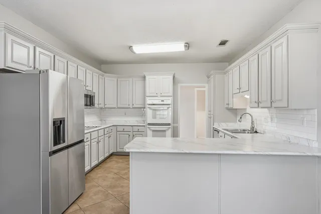 a kitchen with stainless steel appliances granite countertop a refrigerator sink and cabinets