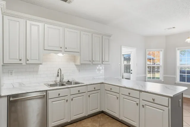 a kitchen with granite countertop white cabinets and white appliances