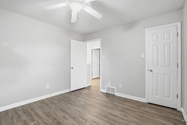 a view of an empty room with wooden floor