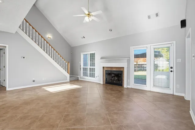 a view of an empty room with a fireplace and a window