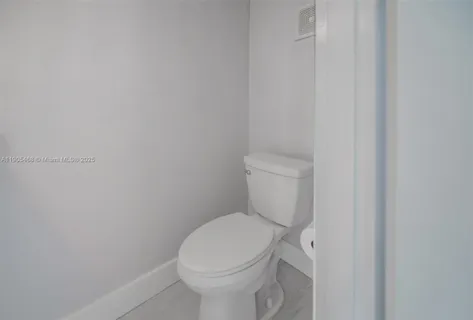 a white toilet sitting next to a white wall