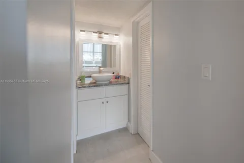 a bathroom with a granite countertop sink and mirror