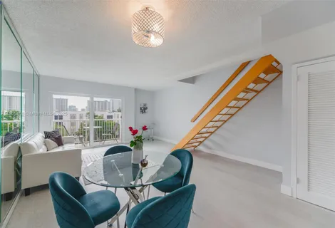 a living room with furniture stairs and a window