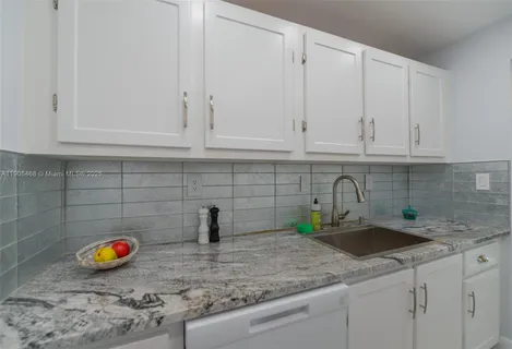a kitchen with stainless steel appliances granite countertop white sink and white cabinets