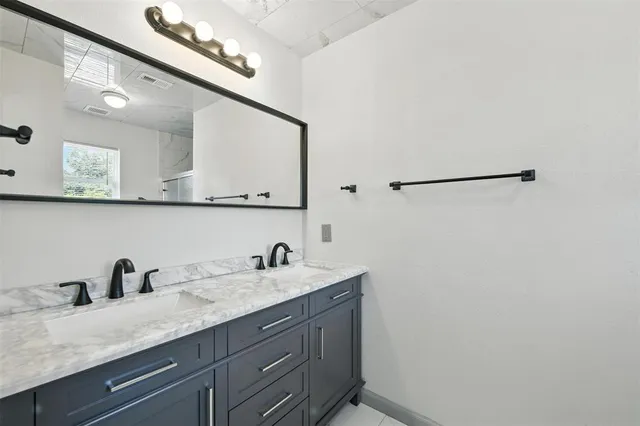 a bathroom with a granite countertop sink a mirror and vanity