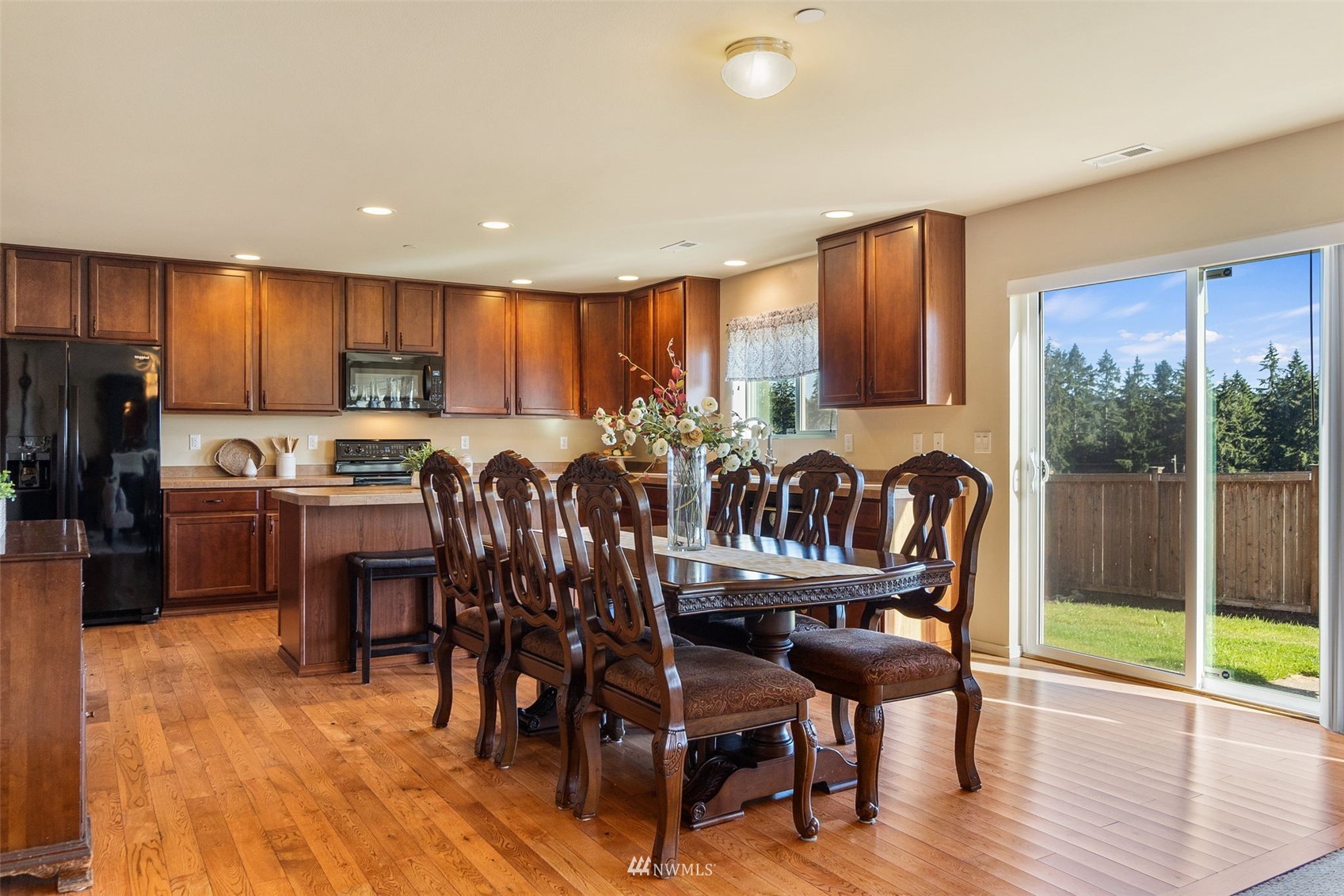 1175 Swan Loop DuPont, WA 98327 - Photo 6 of 33 a view of a dining room with furniture a chandelier and wooden floor
