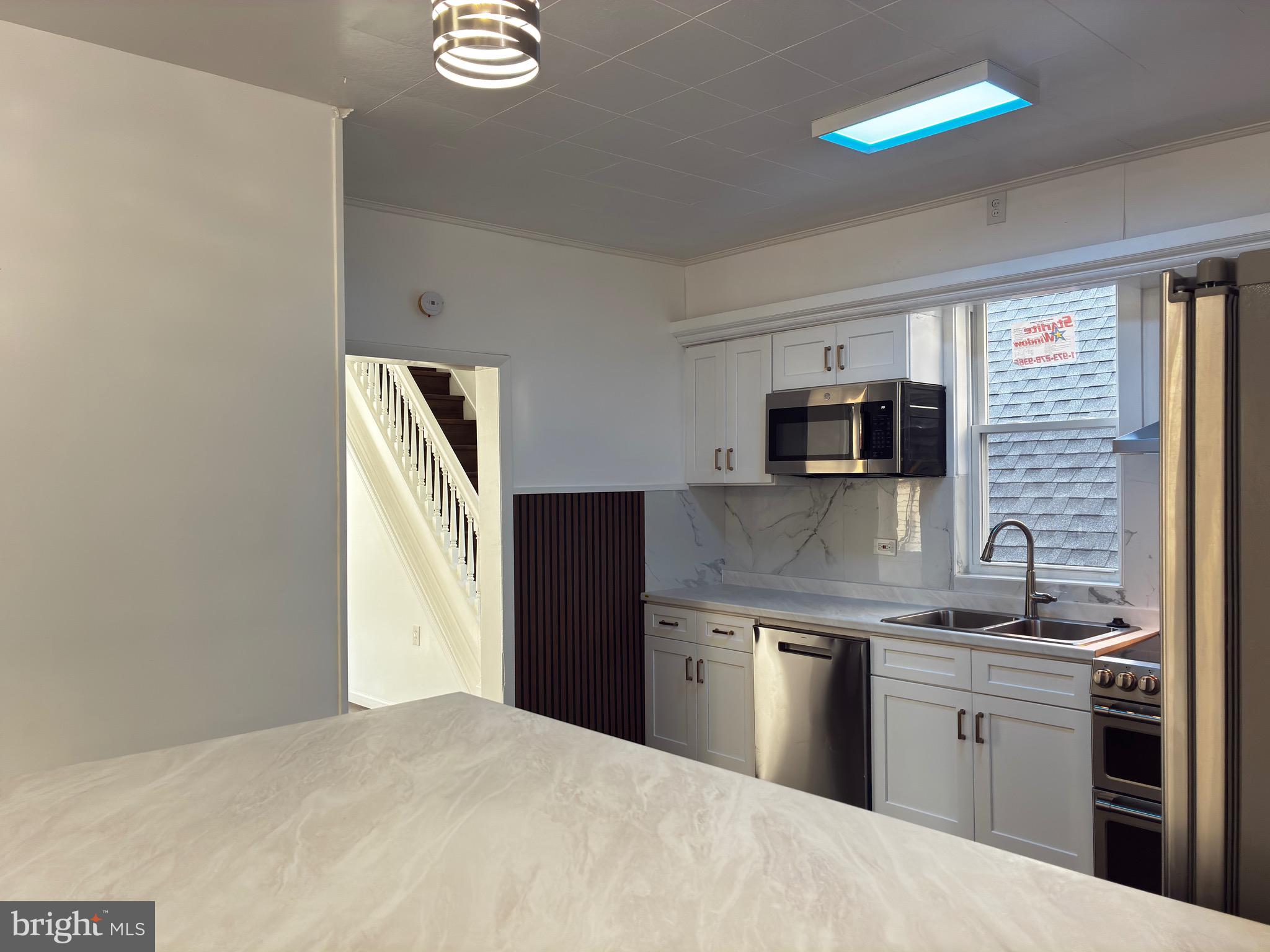 41 South 2nd Street Steelton, PA 17113 - Photo 10 of 24 a kitchen with stainless steel appliances granite countertop a sink dishwasher a stove and a refrigerator with wooden floor