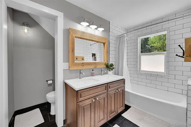 a bathroom with a sink a toilet a mirror and shower