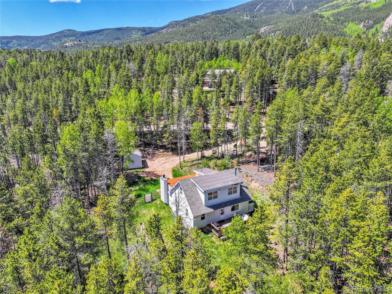 9092 South Gray Lane Conifer, CO 80433 - Photo 22 of 23 a view of a house with a yard and a large tree