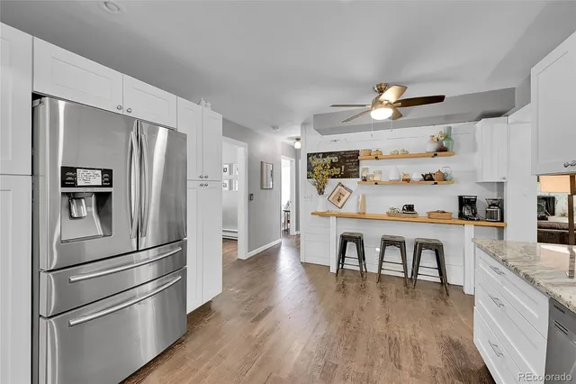 a kitchen with stainless steel appliances a refrigerator and wooden floor