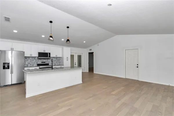 a view of kitchen with kitchen island stainless steel appliances a refrigerator stove and microwave