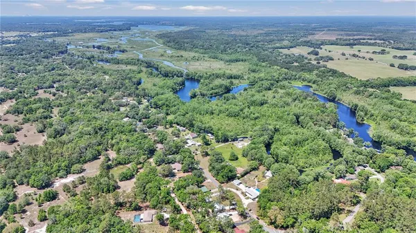 a aerial view of residential house with outdoor space and trees all around