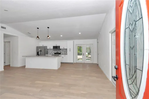 a view of kitchen with stainless steel appliances kitchen island sink and refrigerator
