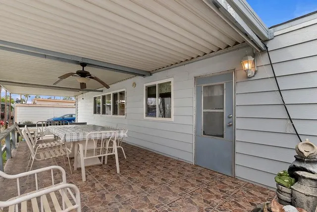 a view of a patio with table and chairs with wooden floor and fence