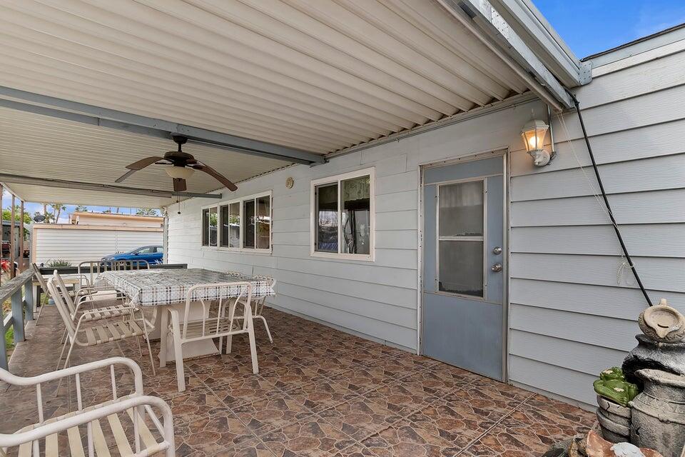 74711 Dillon Road, Unit 308 Desert Hot Springs, CA 92241 - Photo 22 of 42 a view of a patio with table and chairs with wooden floor and fence