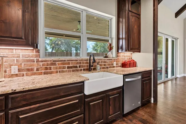 a kitchen with granite countertop a sink and a window