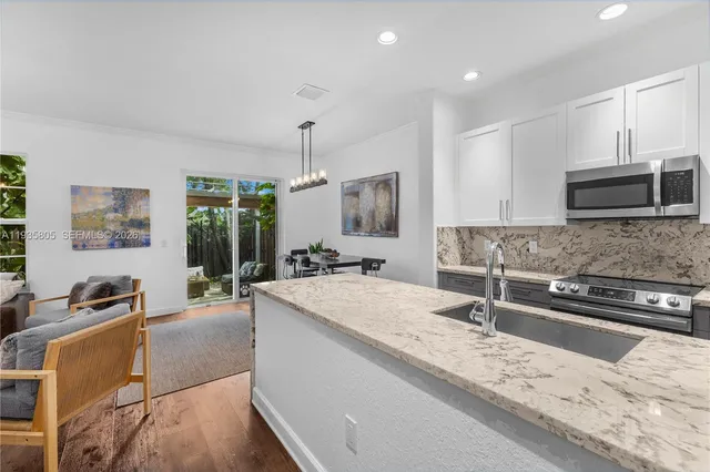 a large kitchen with kitchen island granite countertop a sink and a stove top oven with granite countertops