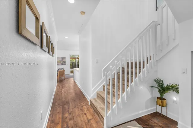 a living room with furniture kitchen view and a wooden floor