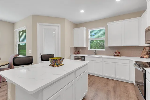 a kitchen with kitchen island a appliances a refrigerator a sink and a stove