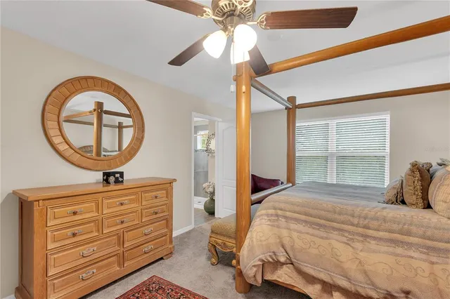 a bedroom with a bed chandelier and a window