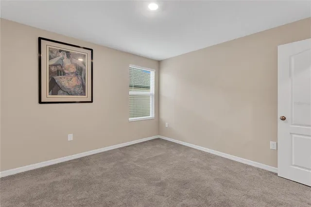 an empty room with windows and painting on the wall