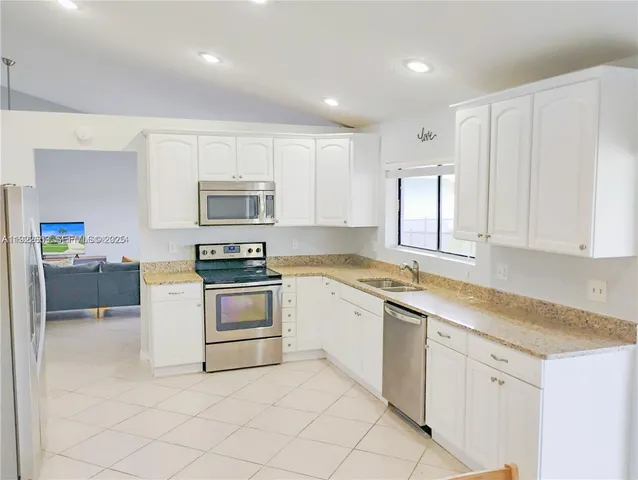 a kitchen with white cabinets and white appliances