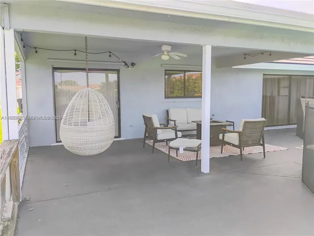 a sign of golf club on a wall under a tree