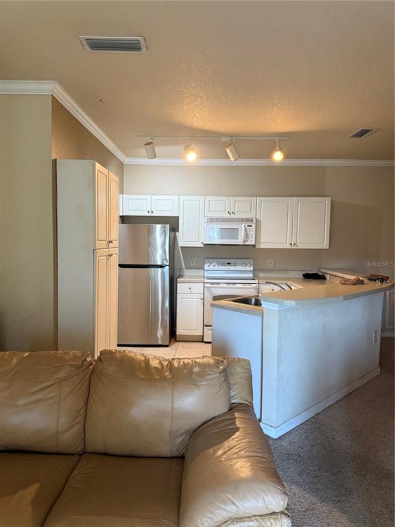 260 Old Village Center Circle, Unit 8205 St. Augustine, FL 32084 - Photo 4 of 13 a kitchen with kitchen island granite countertop a refrigerator a stove and a sink with wooden floor