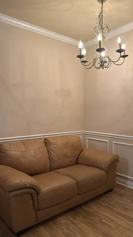a living room with a couch and chandelier
