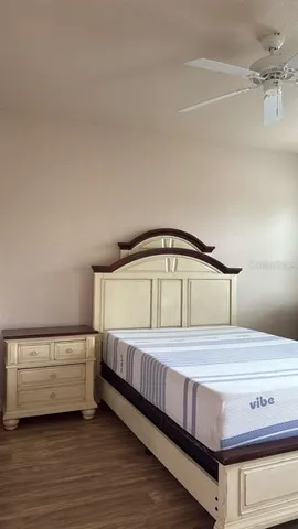 a bedroom with a bed and a ceiling fan