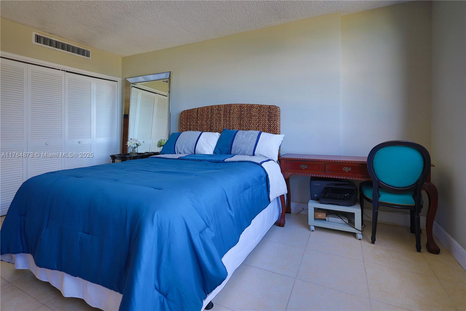 9225 Collins Avenue, Unit 503 Surfside, FL 33154 - Photo 5 of 37 a bedroom with a bed a desk and chair