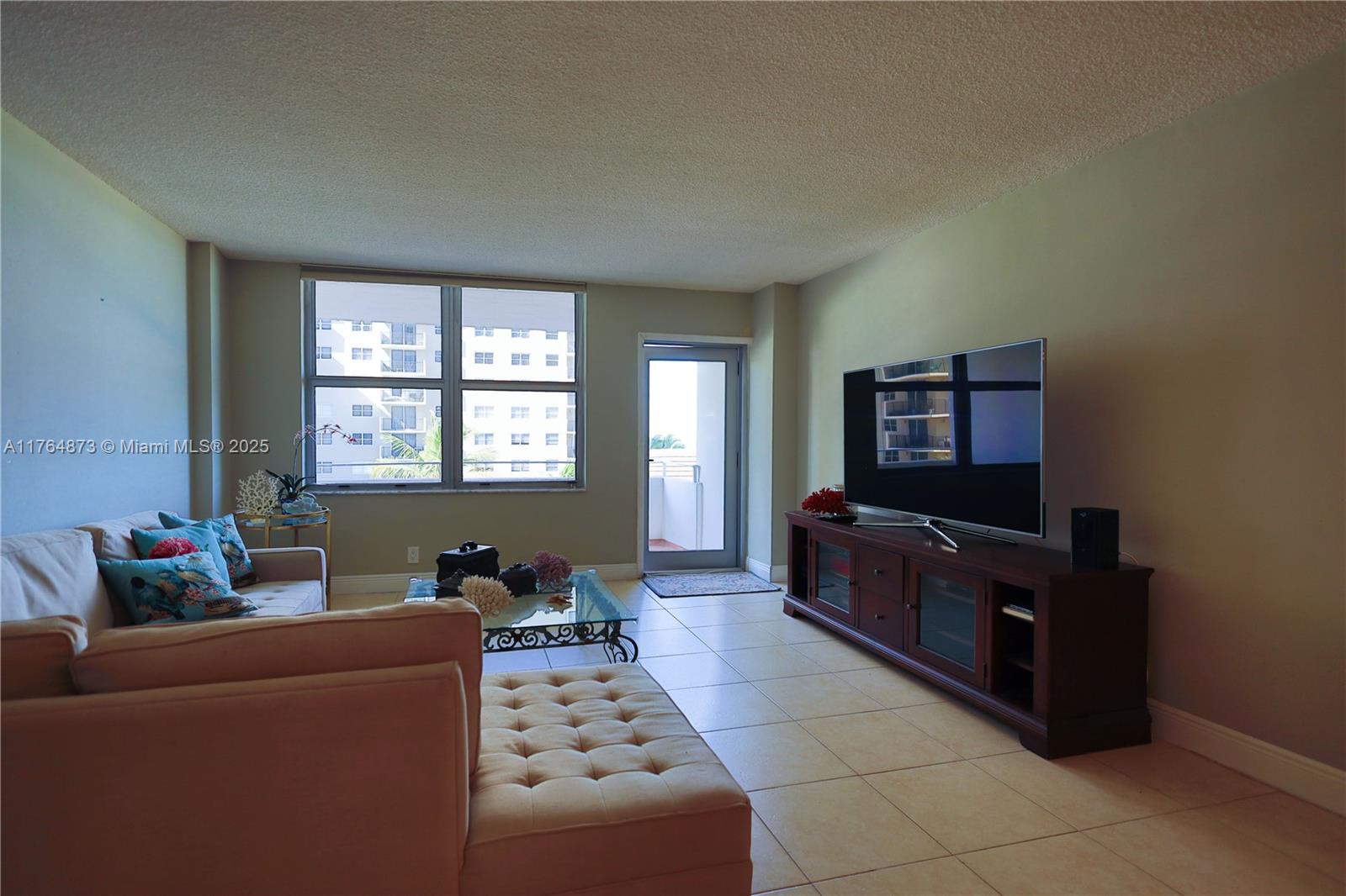 9225 Collins Avenue, Unit 503 Surfside, FL 33154 - Photo 10 of 37 a living room with furniture and a flat screen tv