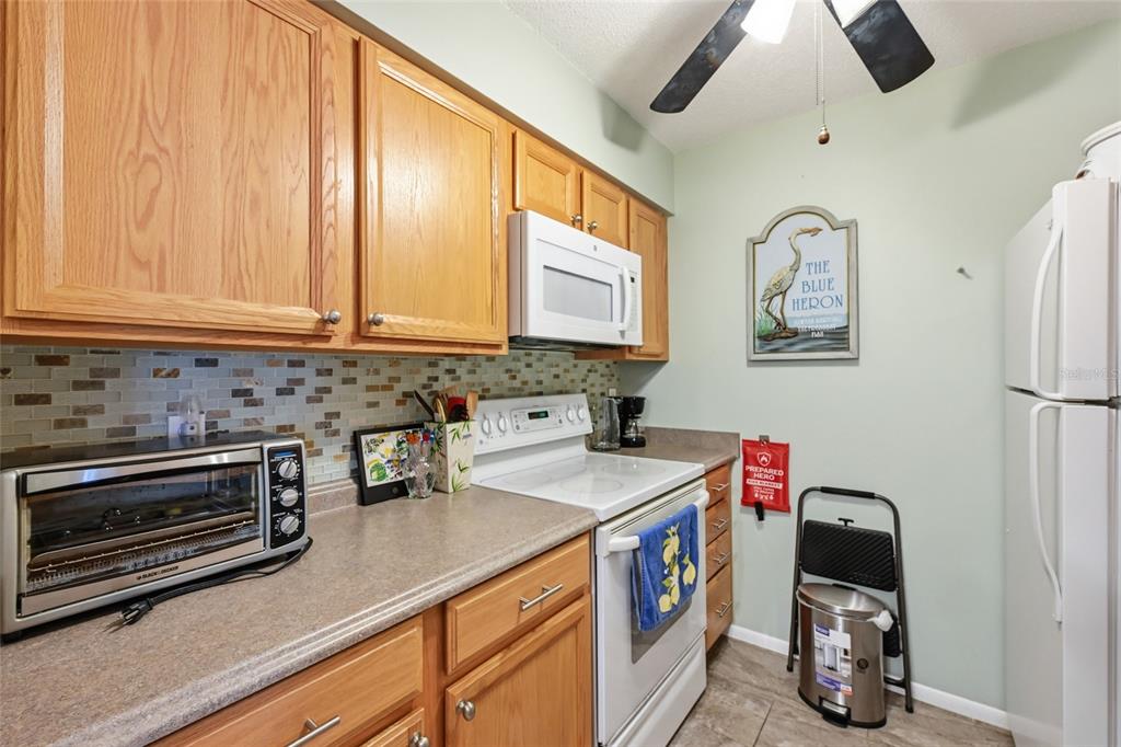 5683 Midnight Pass Road, Unit 110 Sarasota, FL 34242 - Photo 11 of 19 a kitchen with a refrigerator and a sink