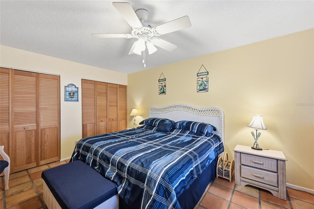 5683 Midnight Pass Road, Unit 110 Sarasota, FL 34242 - Photo 13 of 19 a bedroom with a bed and wooden floor