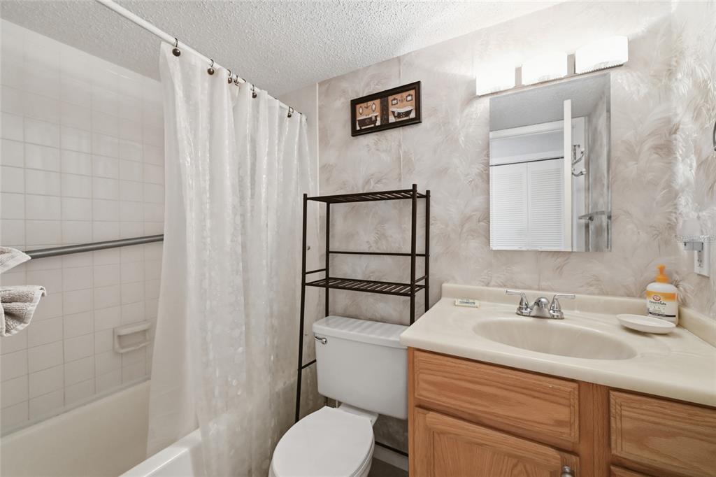 5683 Midnight Pass Road, Unit 110 Sarasota, FL 34242 - Photo 14 of 19 a bathroom with a sink toilet and shower