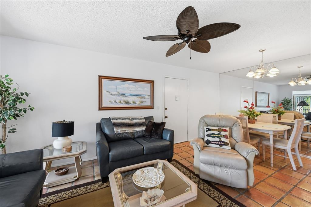 5683 Midnight Pass Road, Unit 110 Sarasota, FL 34242 - Photo 7 of 19 a living room with furniture a window and a chandelier