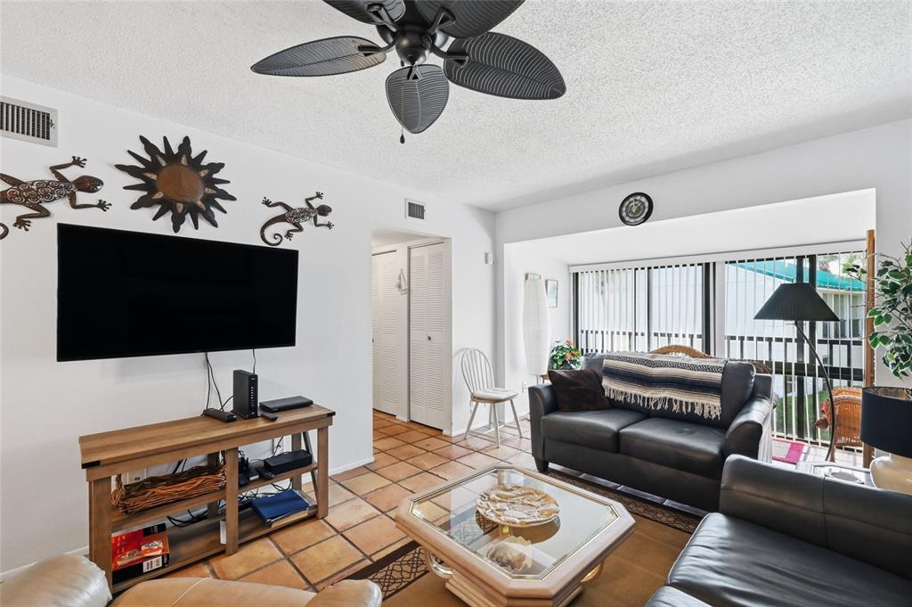 5683 Midnight Pass Road, Unit 110 Sarasota, FL 34242 - Photo 9 of 19 a living room with furniture and a flat screen tv